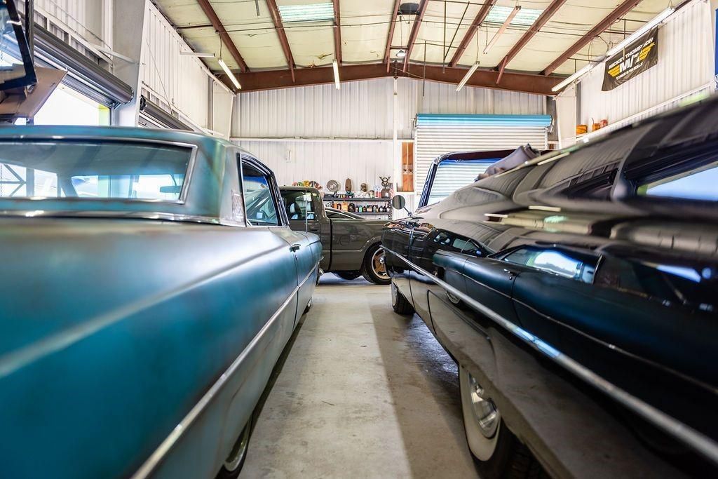 A row of cars are parked in a garage.