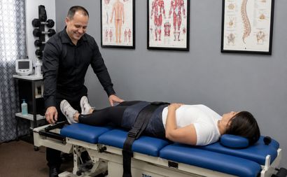 Chiropractor adjusting a patient lying down using a decompression table
