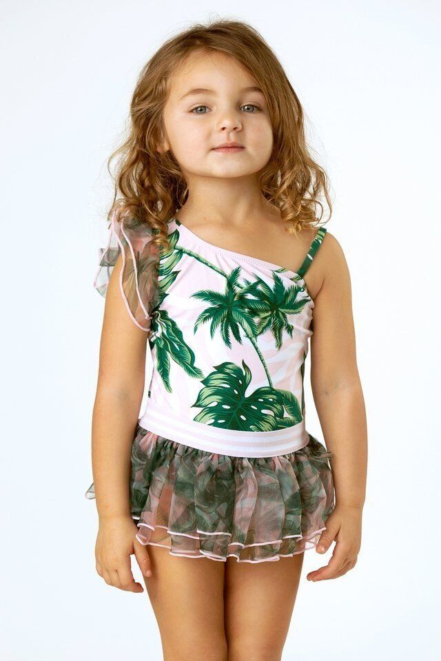 A little girl is wearing a swimsuit with palm trees on it.
