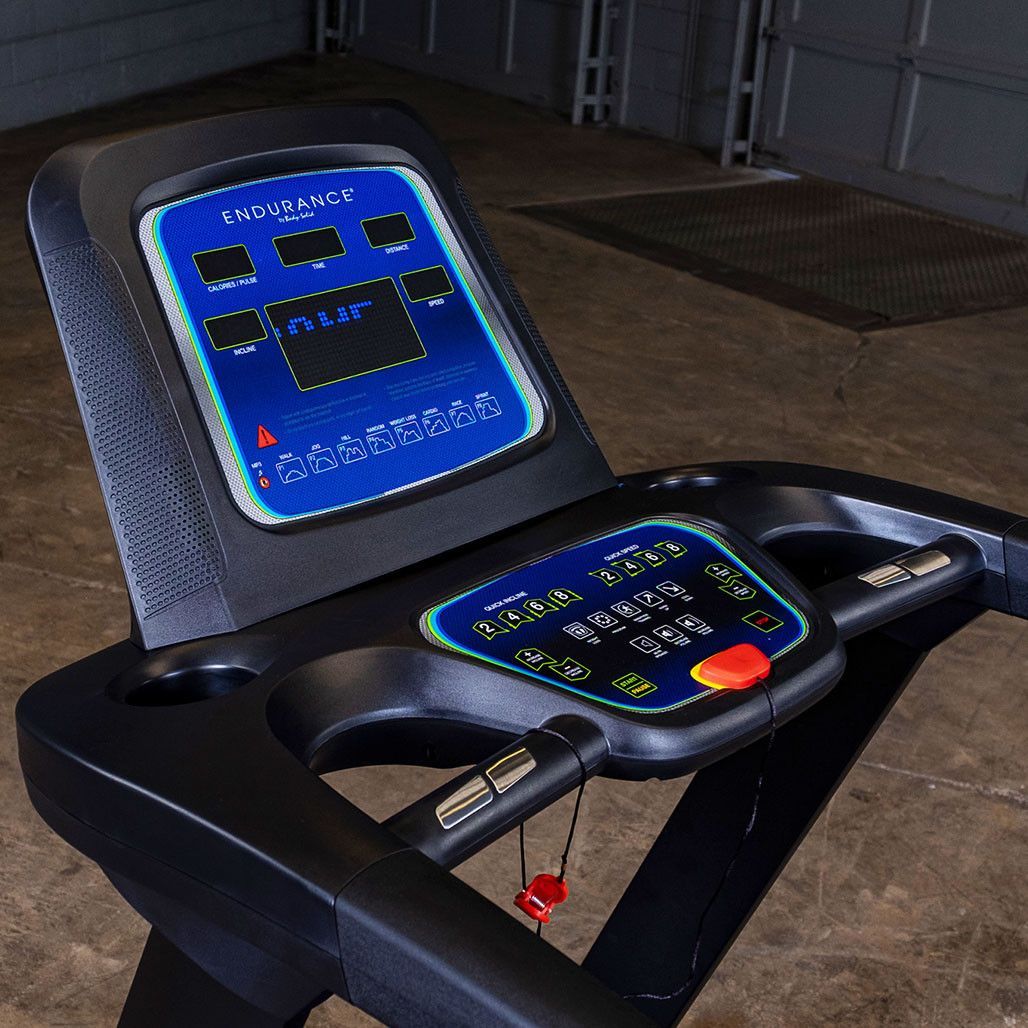Black treadmill with blue-lit console on a white background