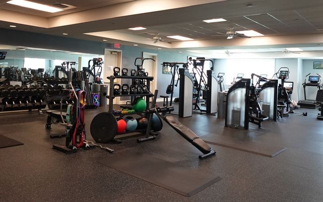 Empty gym with weight machines, benches, and exercise balls.