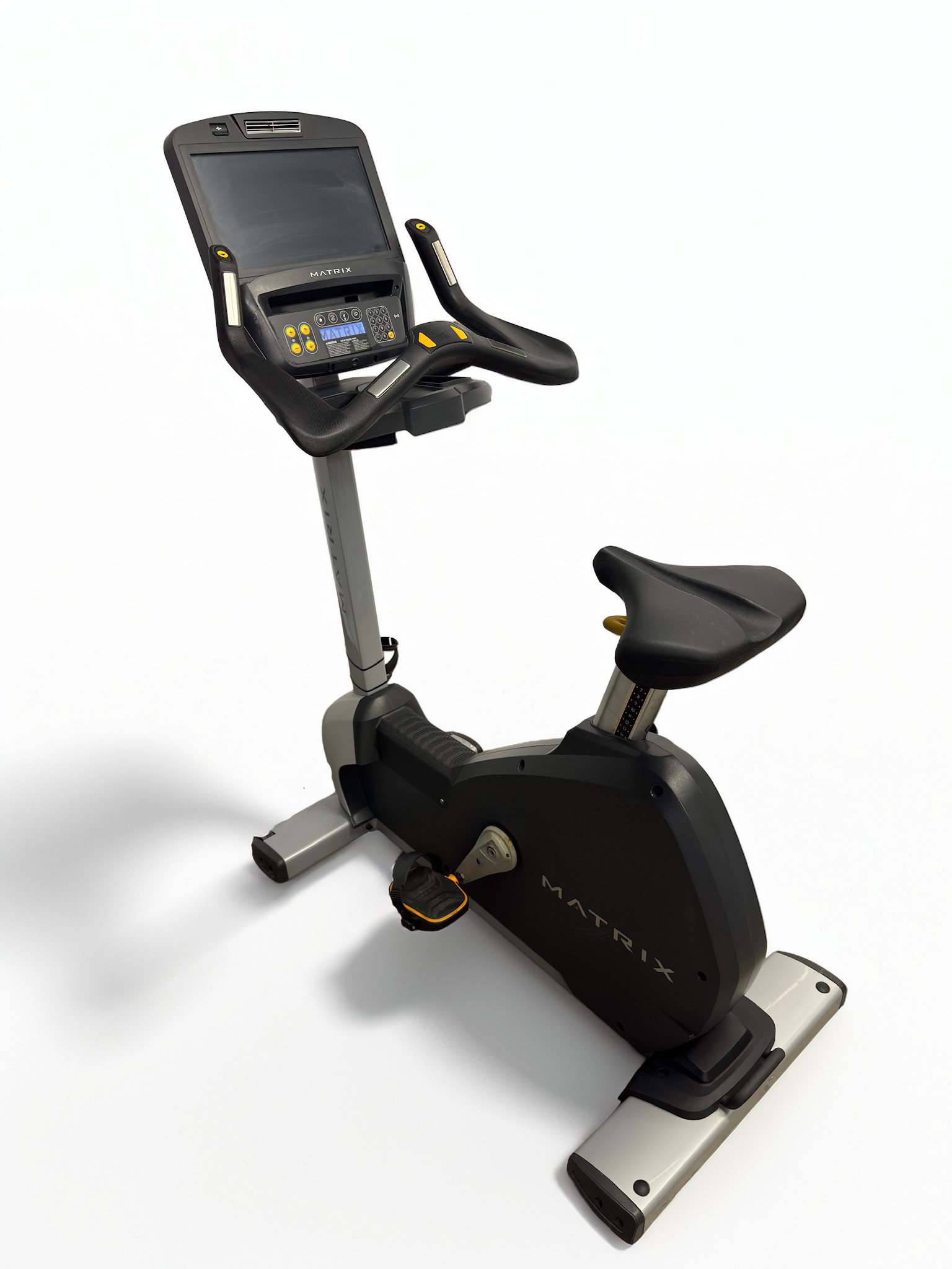 Black stationary exercise bike with a digital console and padded seat on a white background