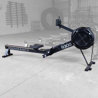 Black Endurance R300 rowing machine in a gym-like room, viewed from the side