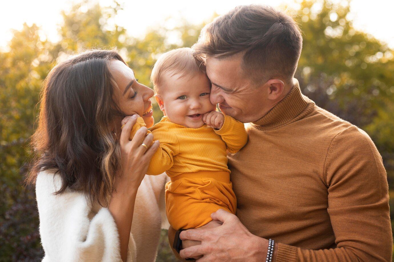 A man and a woman are holding a baby in their arms.