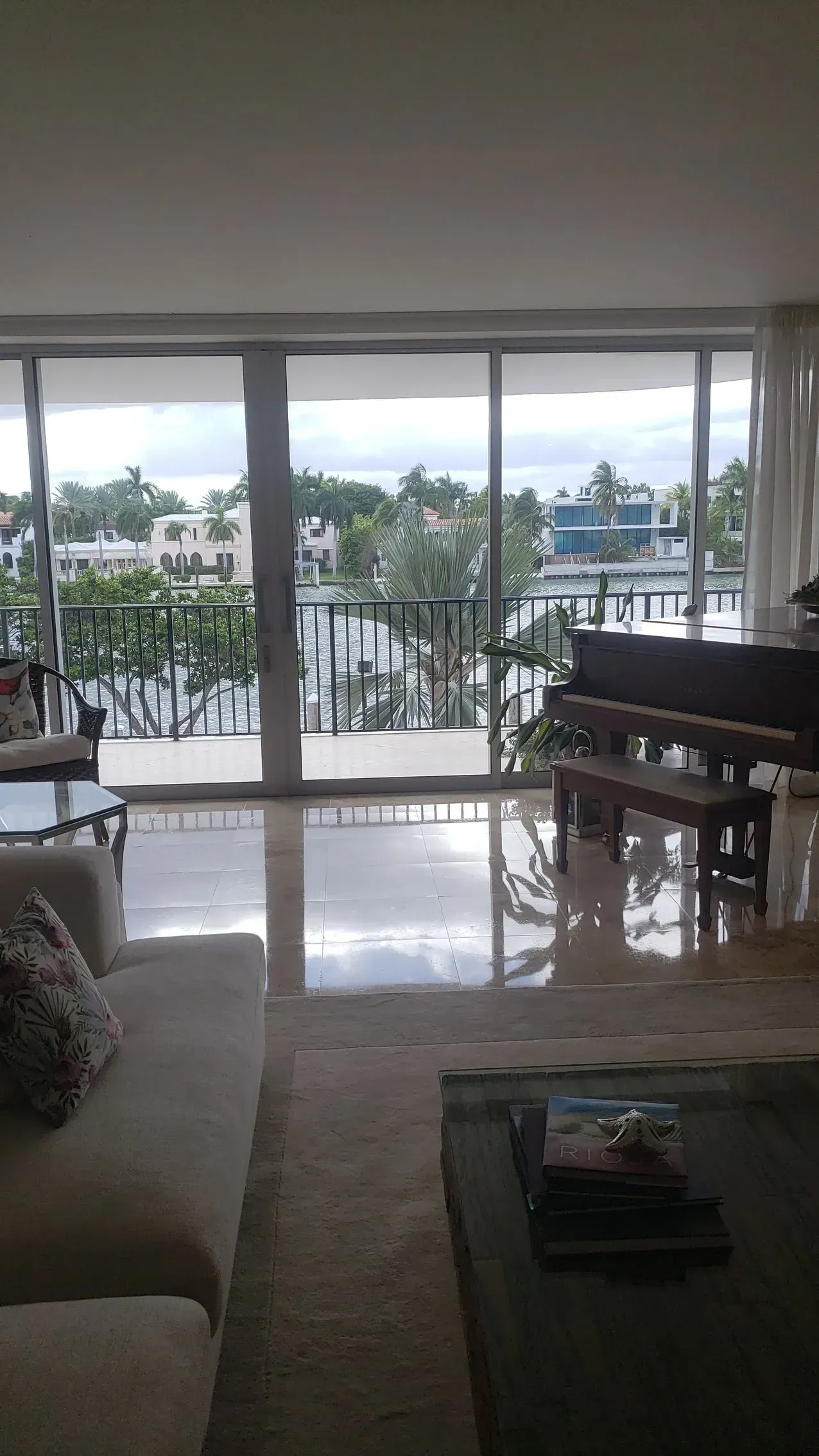 Living room with large glass doors opening to a balcony and water view