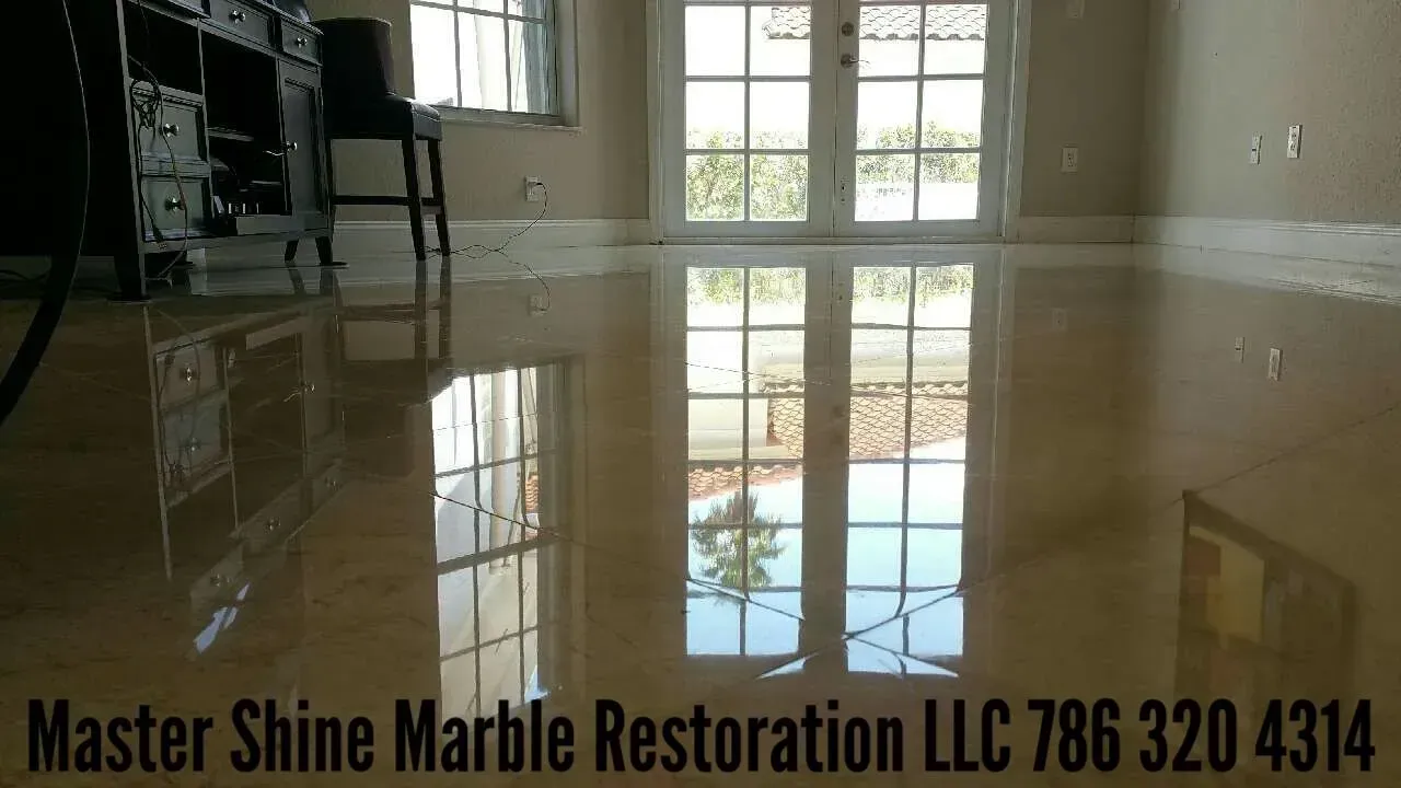 Shiny marble floor reflecting windows in a bright room, with “Master Shine Marble Restoration LLC” text at bottom
