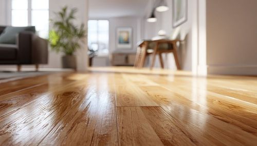 Sunlit hardwood floor in a bright, modern living room with blurred furniture in the background