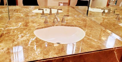 Marble restaurant table set with folded napkins, glasses, and a white plate in the center