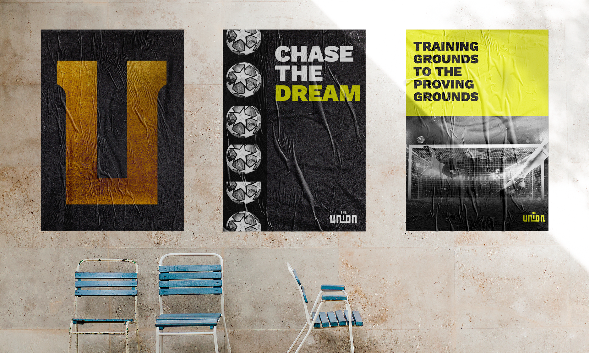 Three posters on a wall with text and soccer imagery. Two blue chairs in front.