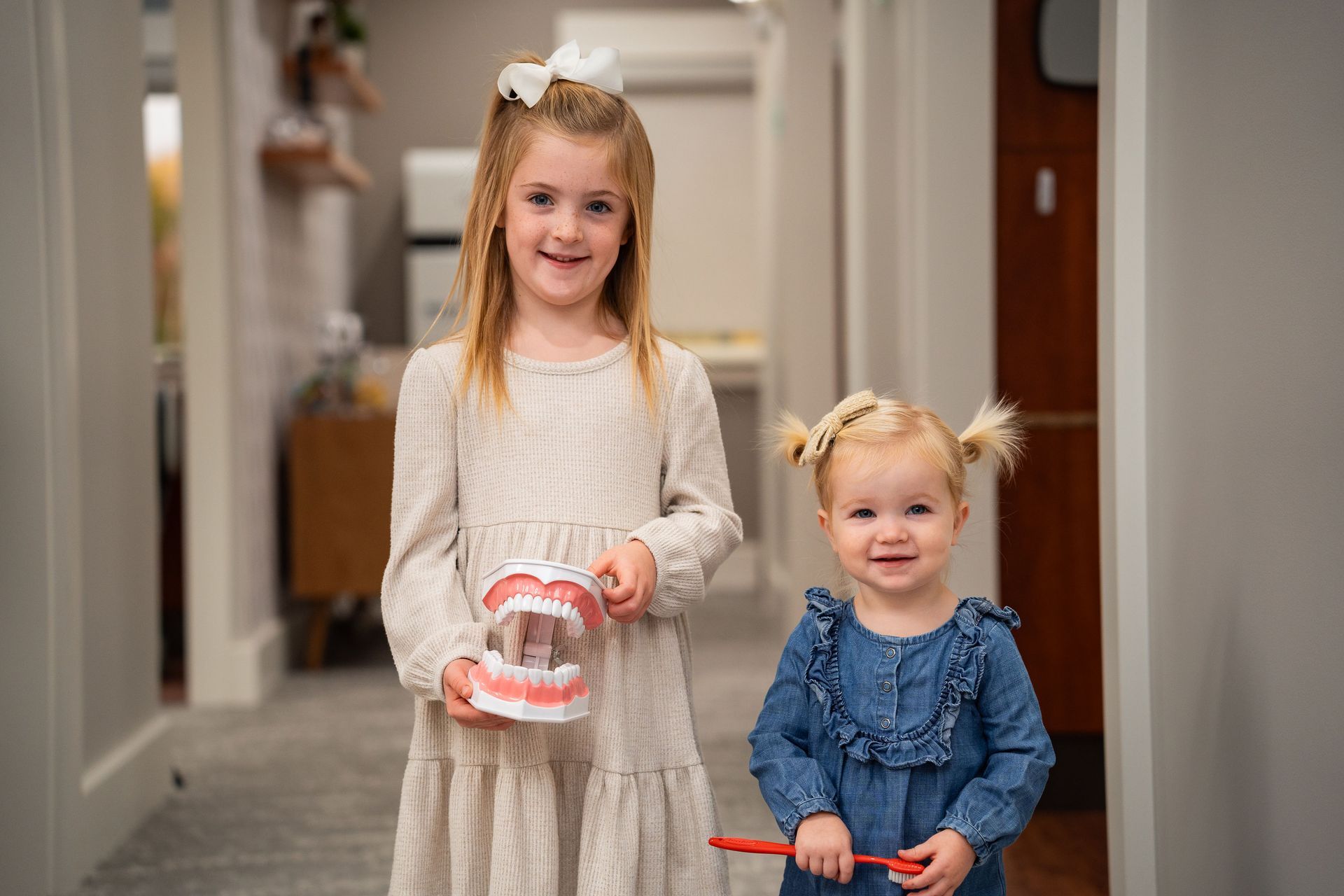 Two young girls smiling, after a gentle pediatric dental cleaning at McMahon Dental.