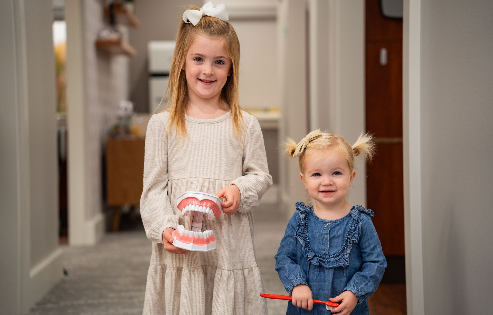 Two young girls smiling, after a gentle pediatric dental cleaning at McMahon Dental.