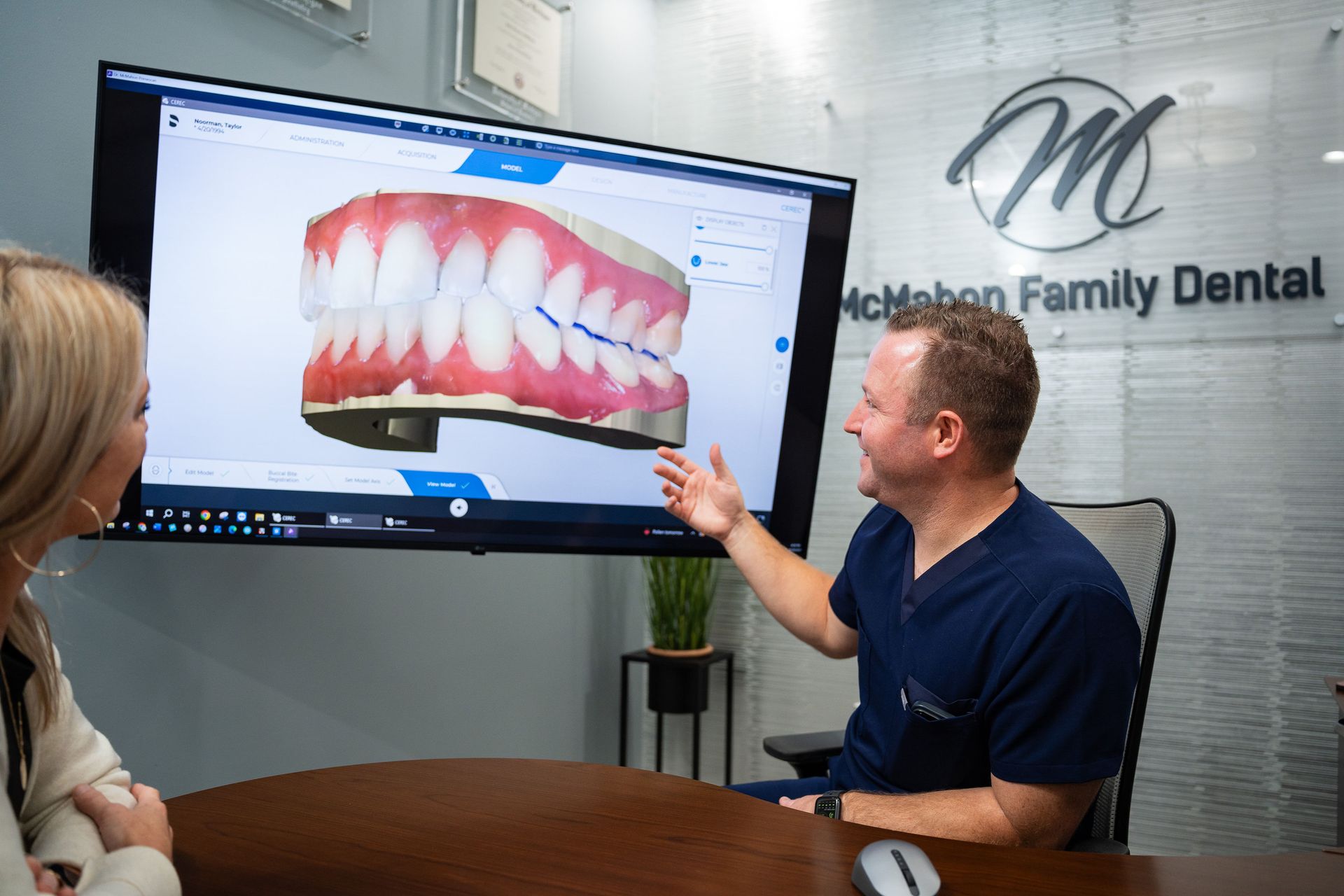Dr. McMahon showing a patient a 3D model of teeth on a screen at McMahon Dental.