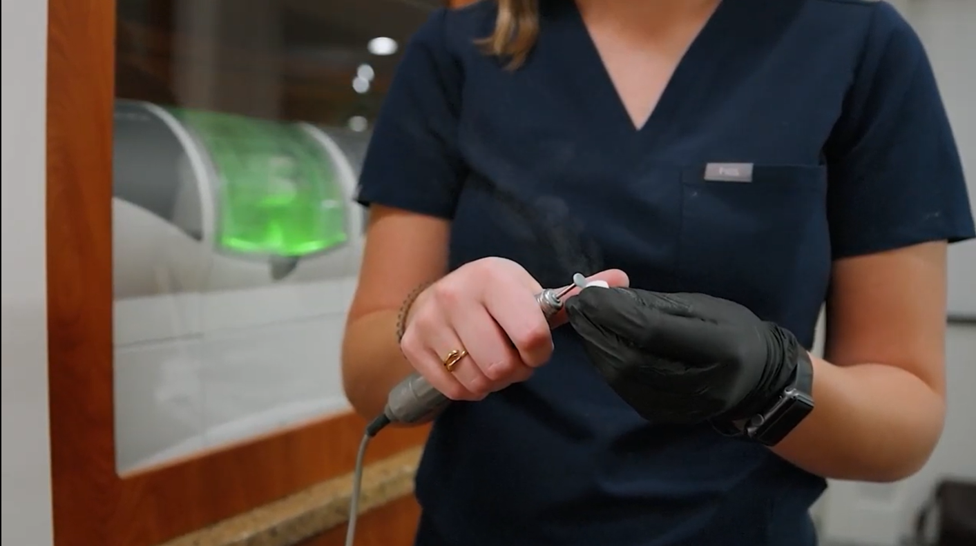 Elyse wearing black gloves working in McMahon's dental lab.