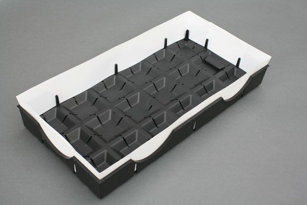 Black and white foam tray with grid-like interior and raised edges, likely for packaging or storage.