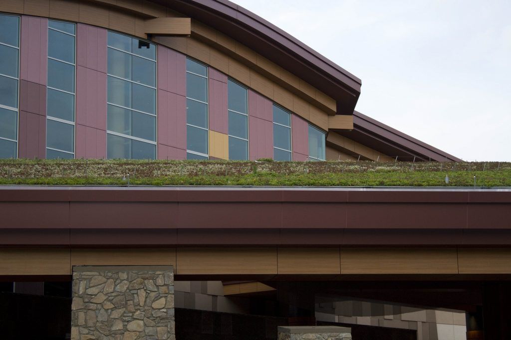 Building with green roof, brown and red panels, and arched windows.