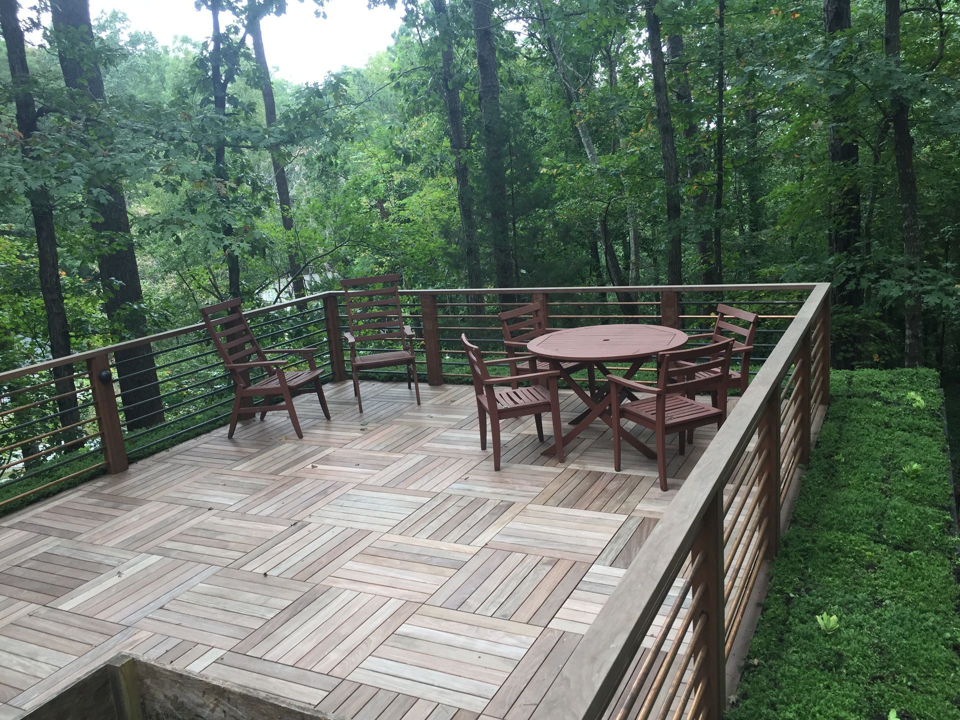 Wooden deck with seating overlooking a forest.