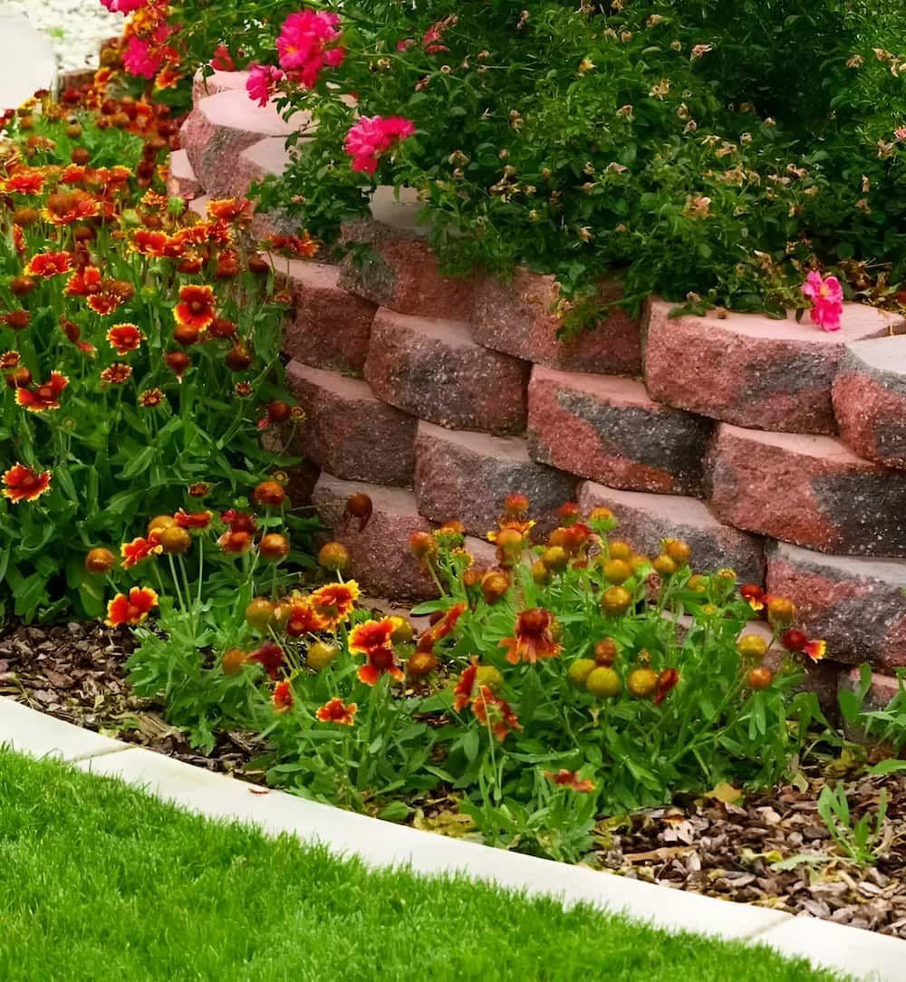 A Brick Wall Surrounded by Flowers in a Garden — Simon Dickson Excavations in Moss Vale, NSW