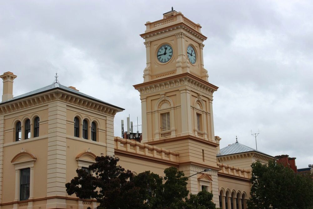 A Large Building With A Clock Tower On Top Of It — Simon Dickson Excavations in Goulburn, NSW