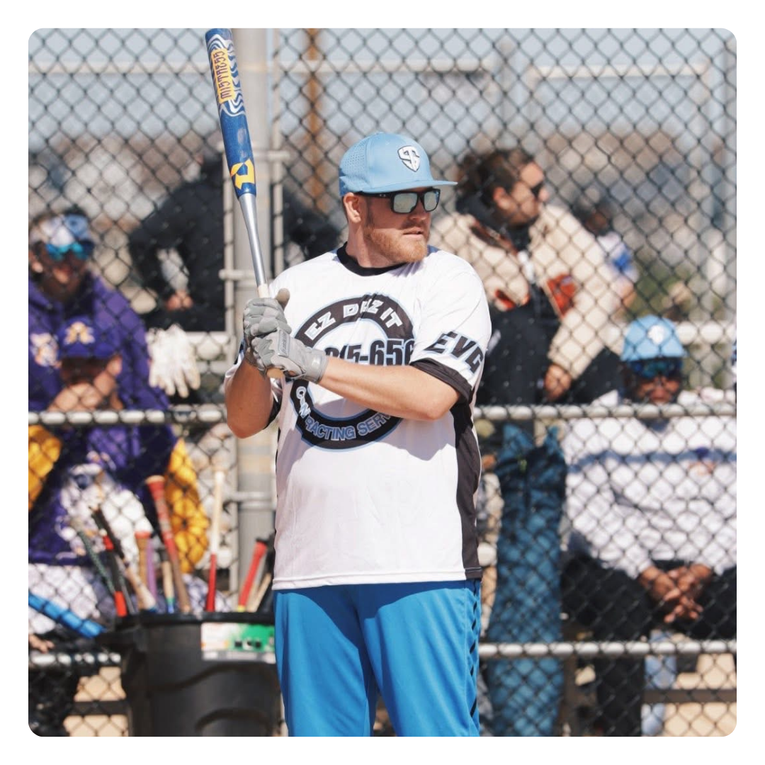 JD Huffman leaning on a fence post with primetime landscaping company trucks in background