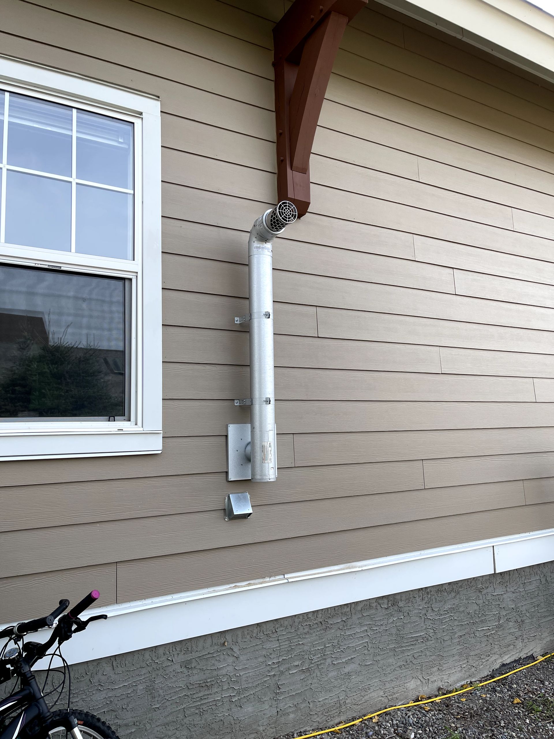 A bicycle is parked on the side of a house