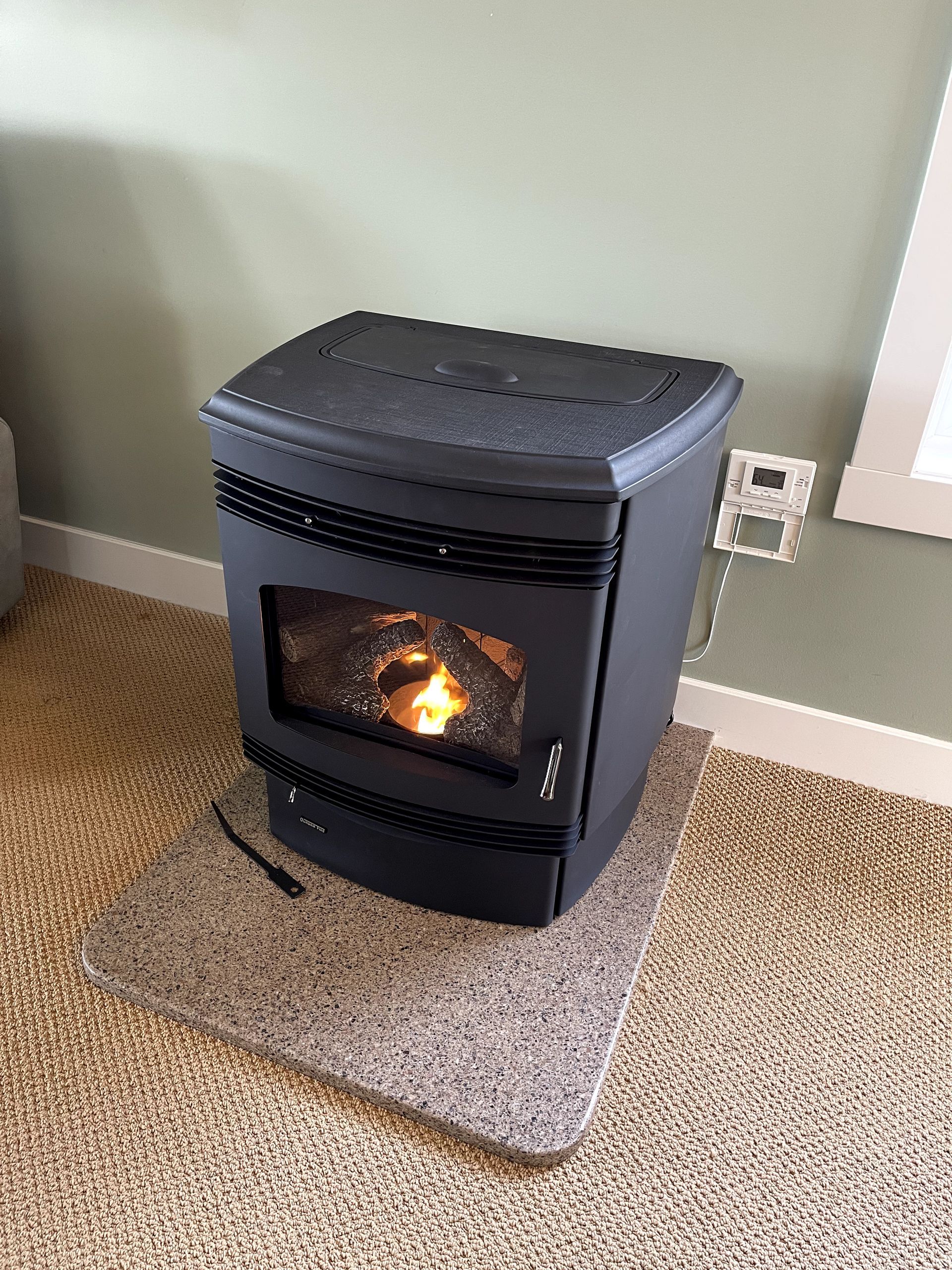 A black wood stove is sitting on a carpeted floor in a living room.