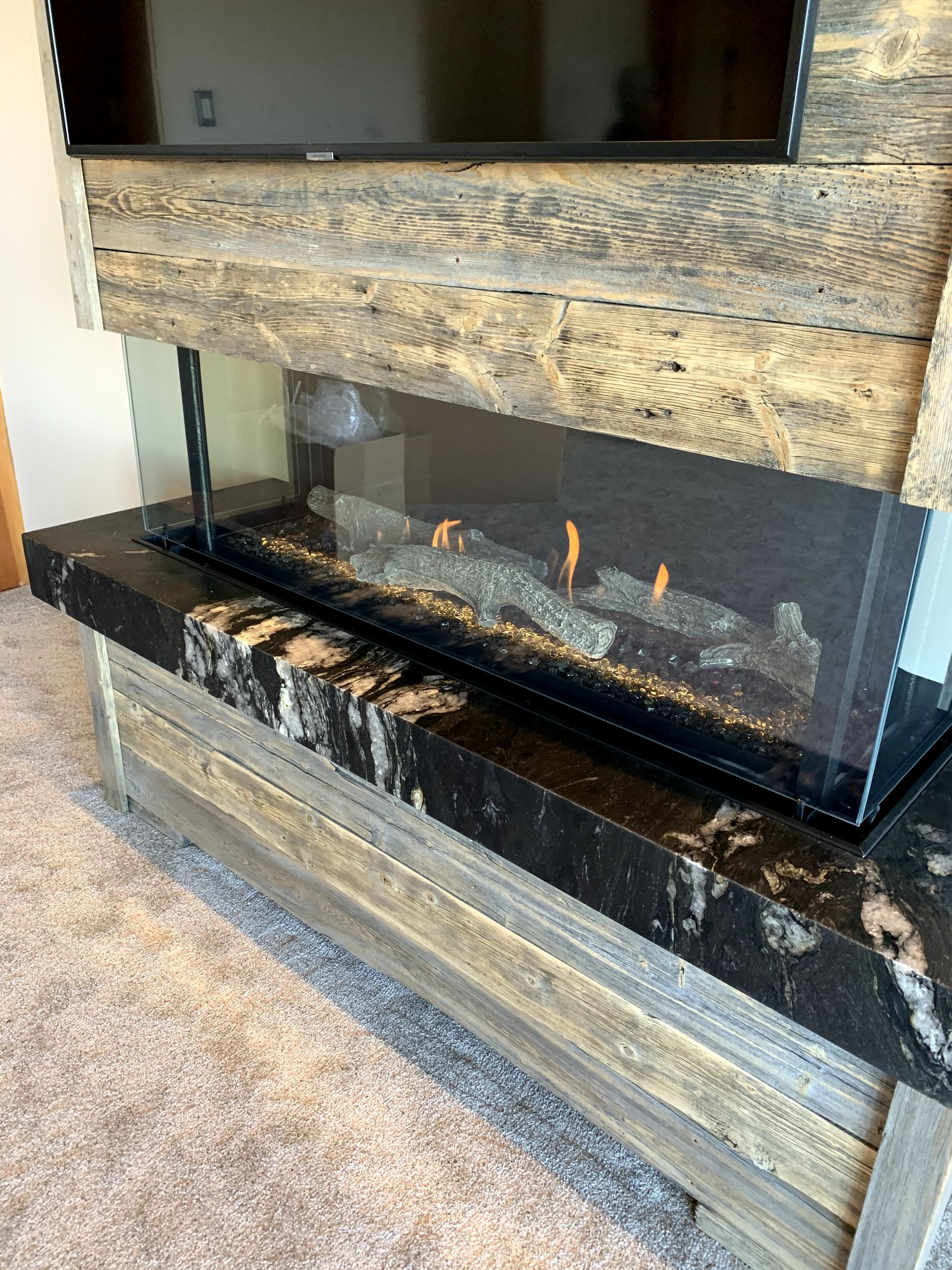 A fireplace with a television mounted on the wall in a living room.