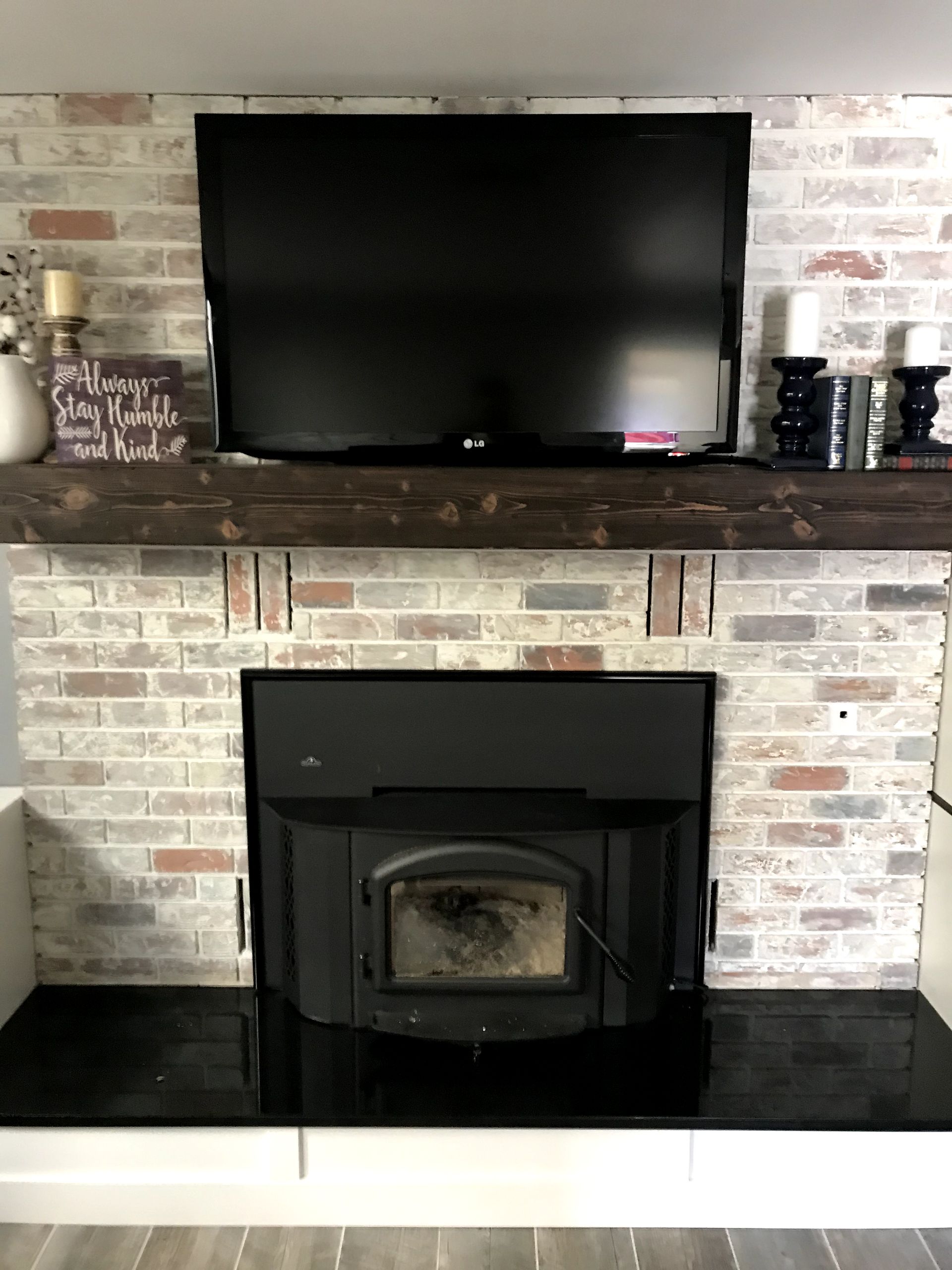 A fireplace with a flat screen tv on top of it.