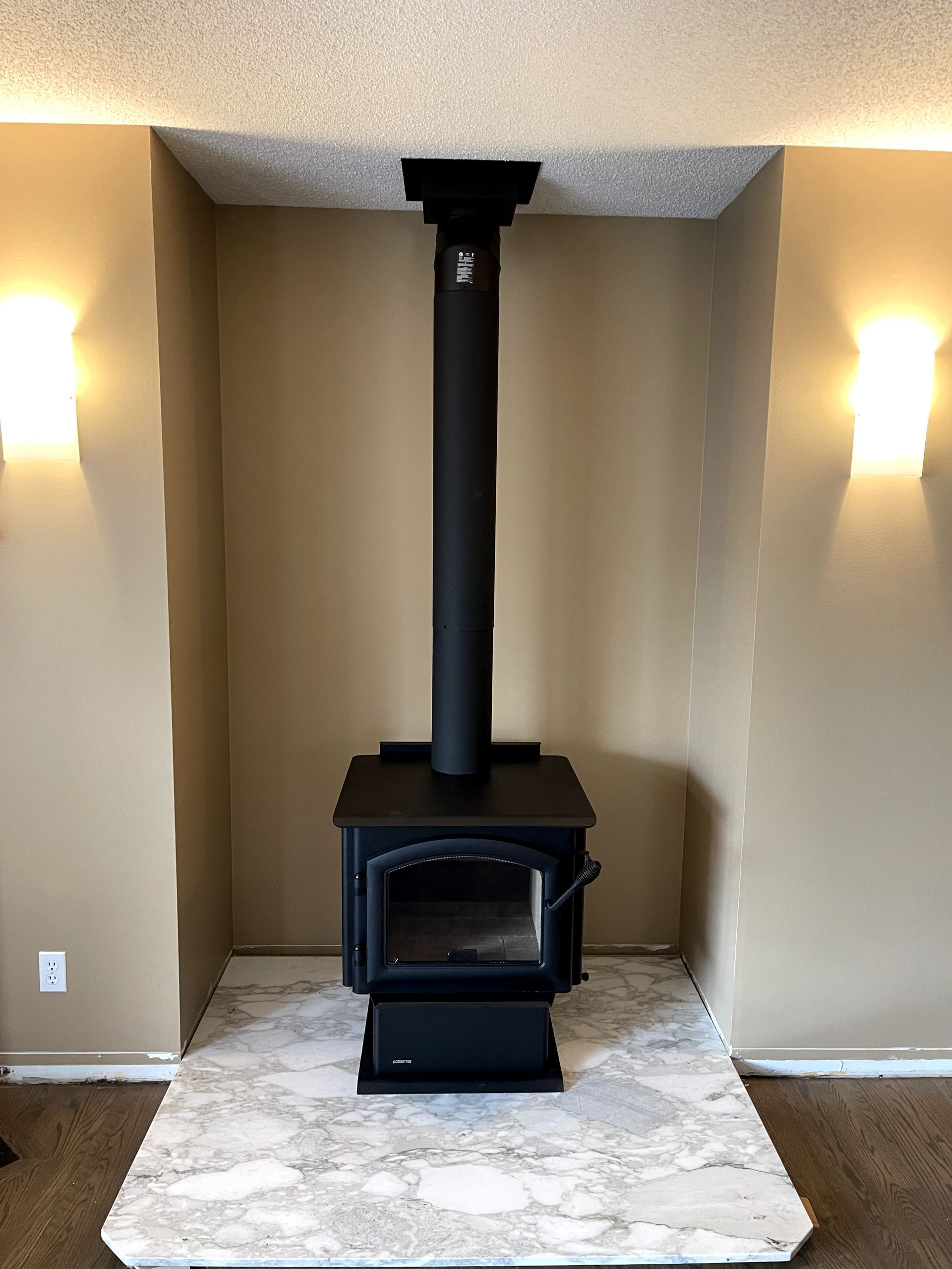 A wood stove is sitting in a corner of a living room.