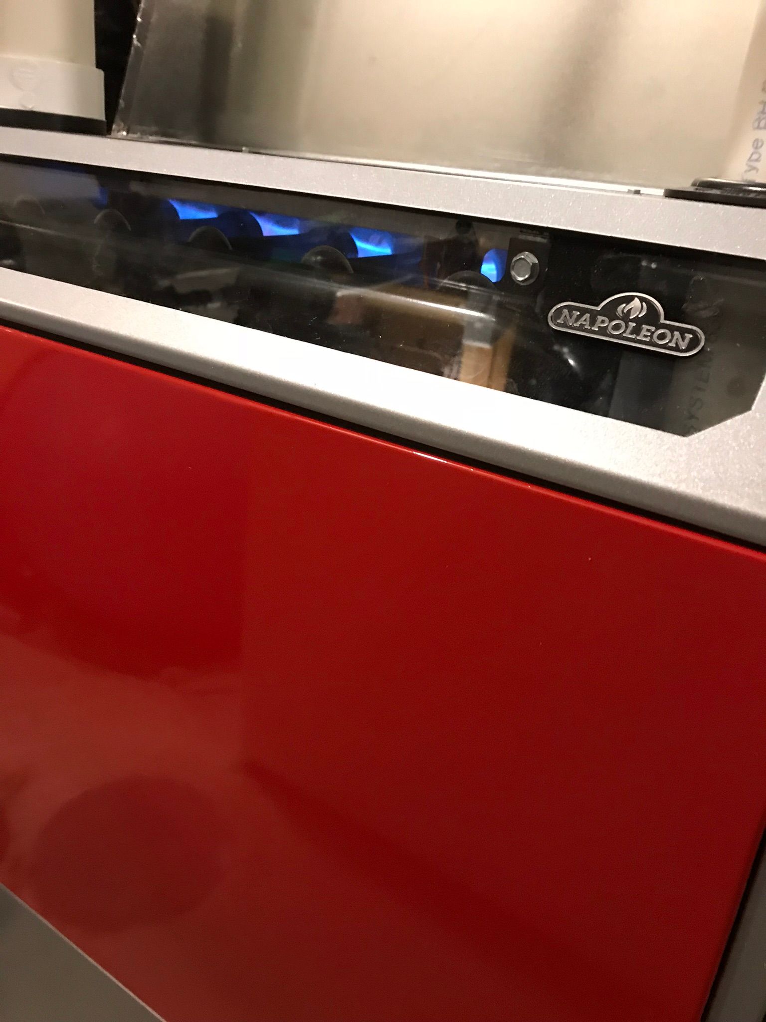 A red cabinet with a stainless steel stove in the background