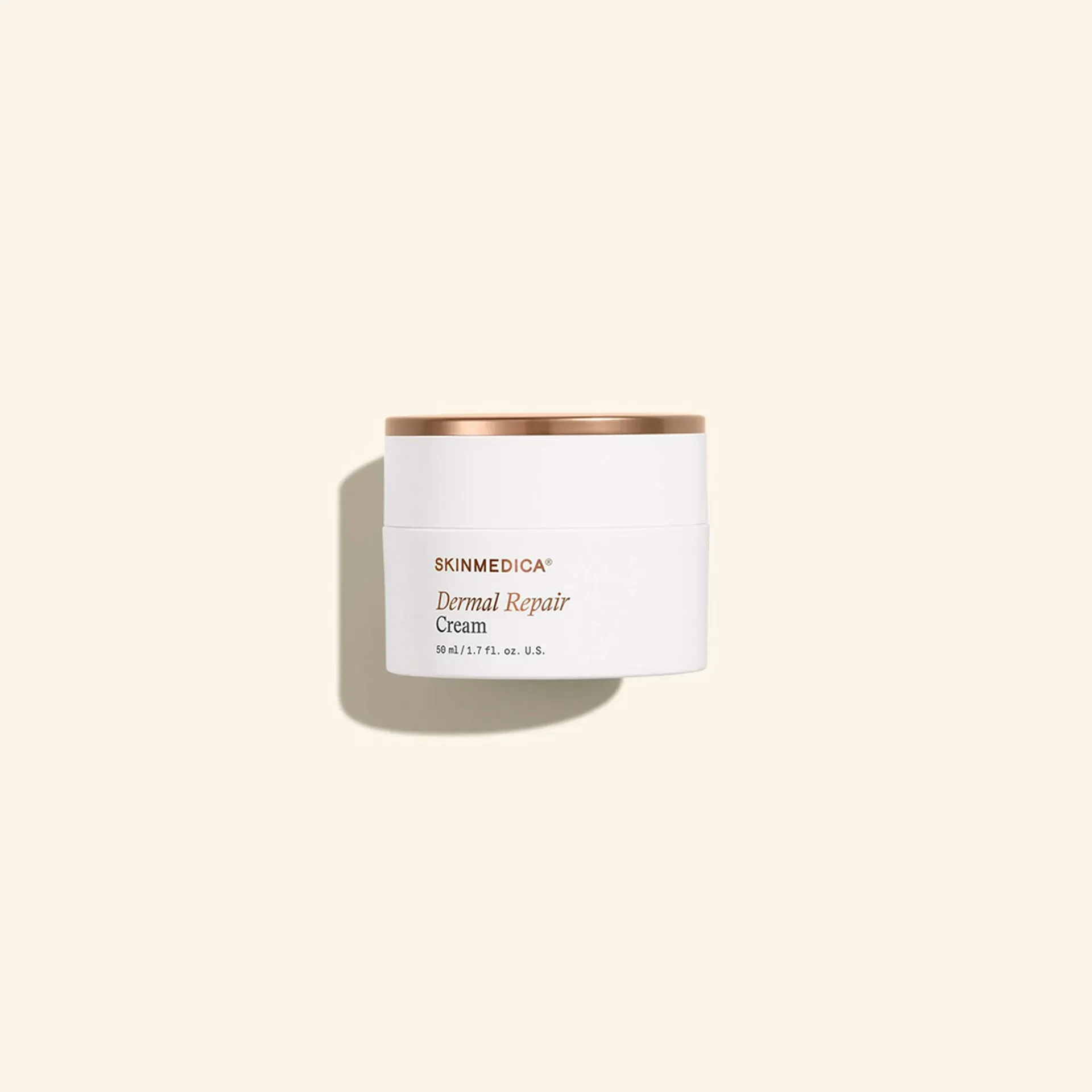 Small white candle tin with rose-gold lid on a beige background