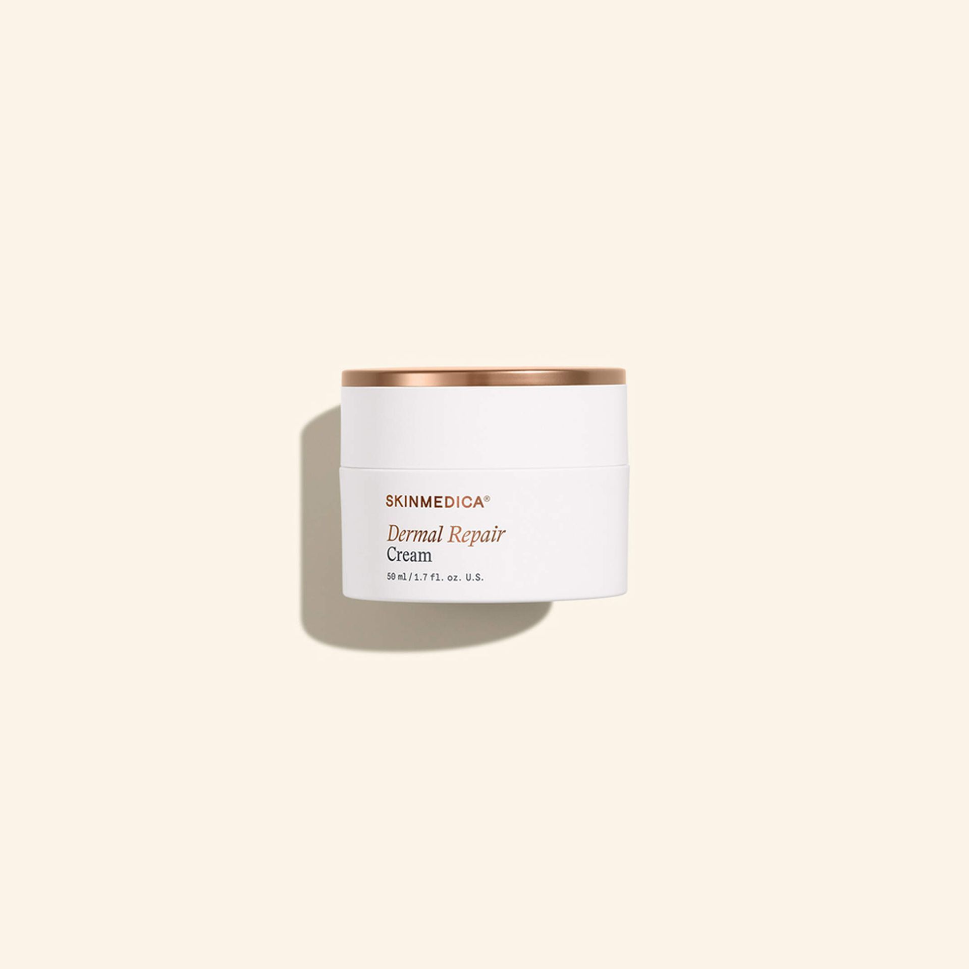 White candle tin with gold lid on a beige background, casting a soft shadow