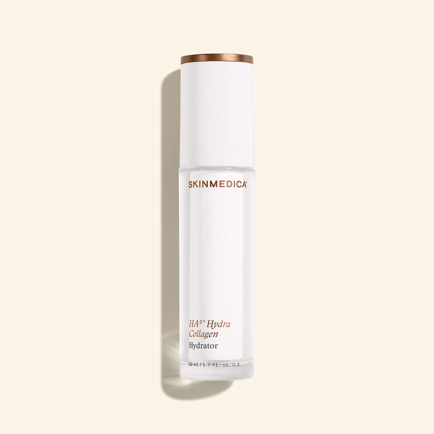 White skincare bottle with gold cap on a light beige background