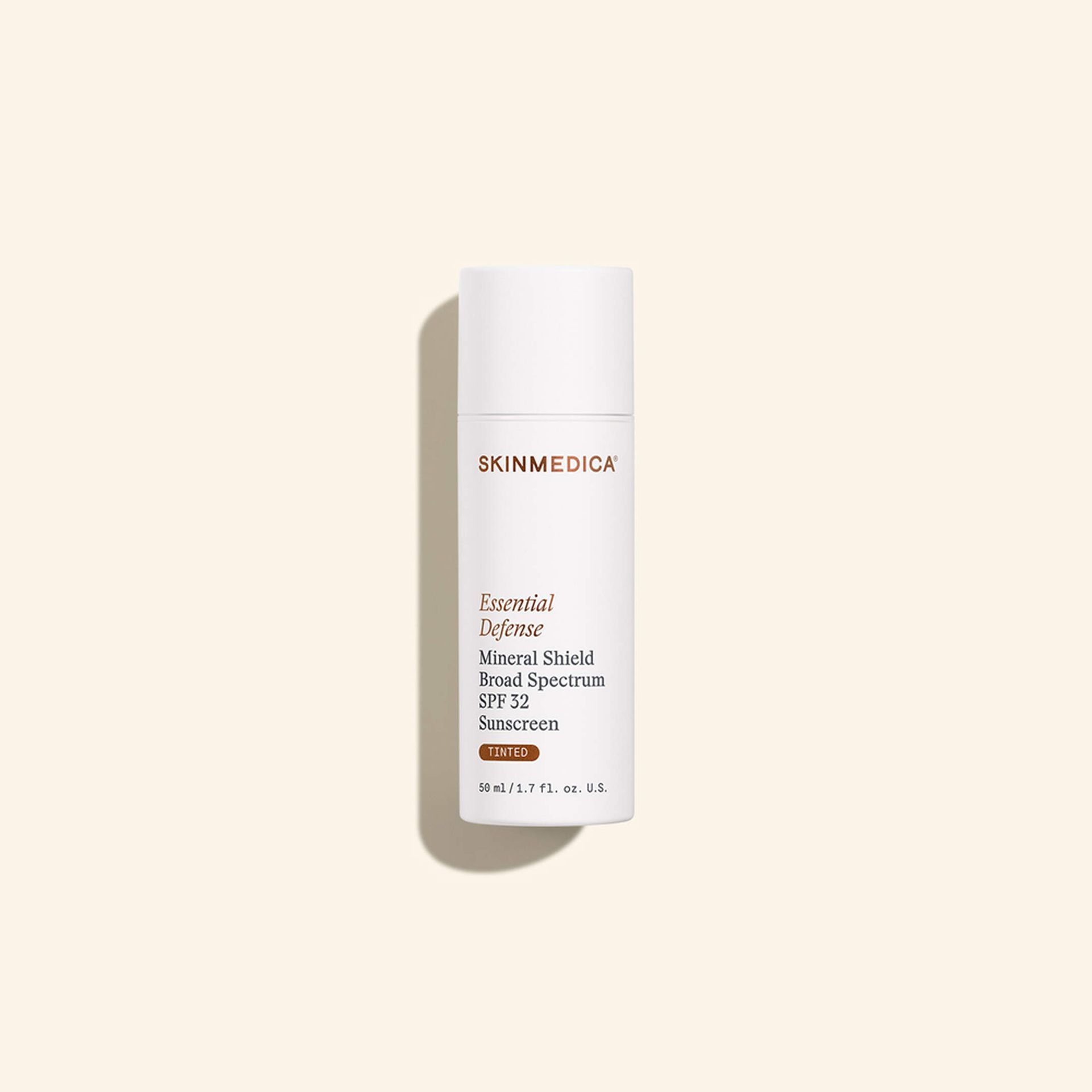 White cylindrical skincare bottle with gold text on a beige background