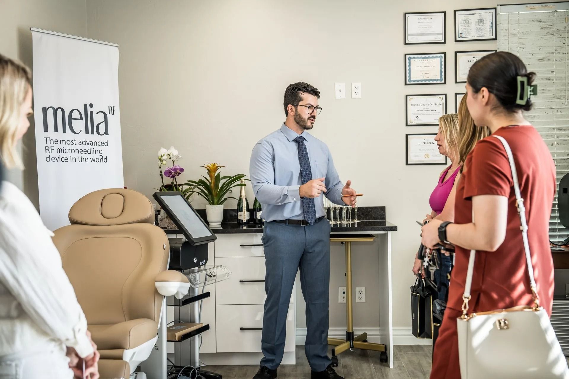 Optometrist speaking with two clients in a bright eyeglass showroom and exam area