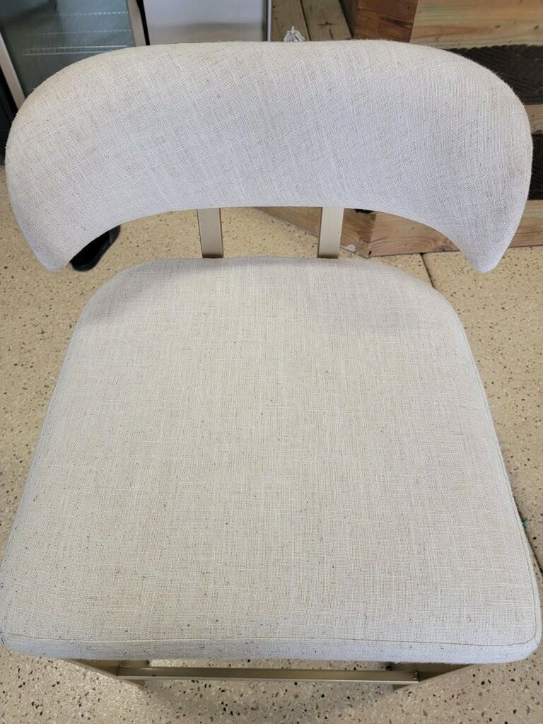 A white chair is sitting on a tiled floor.