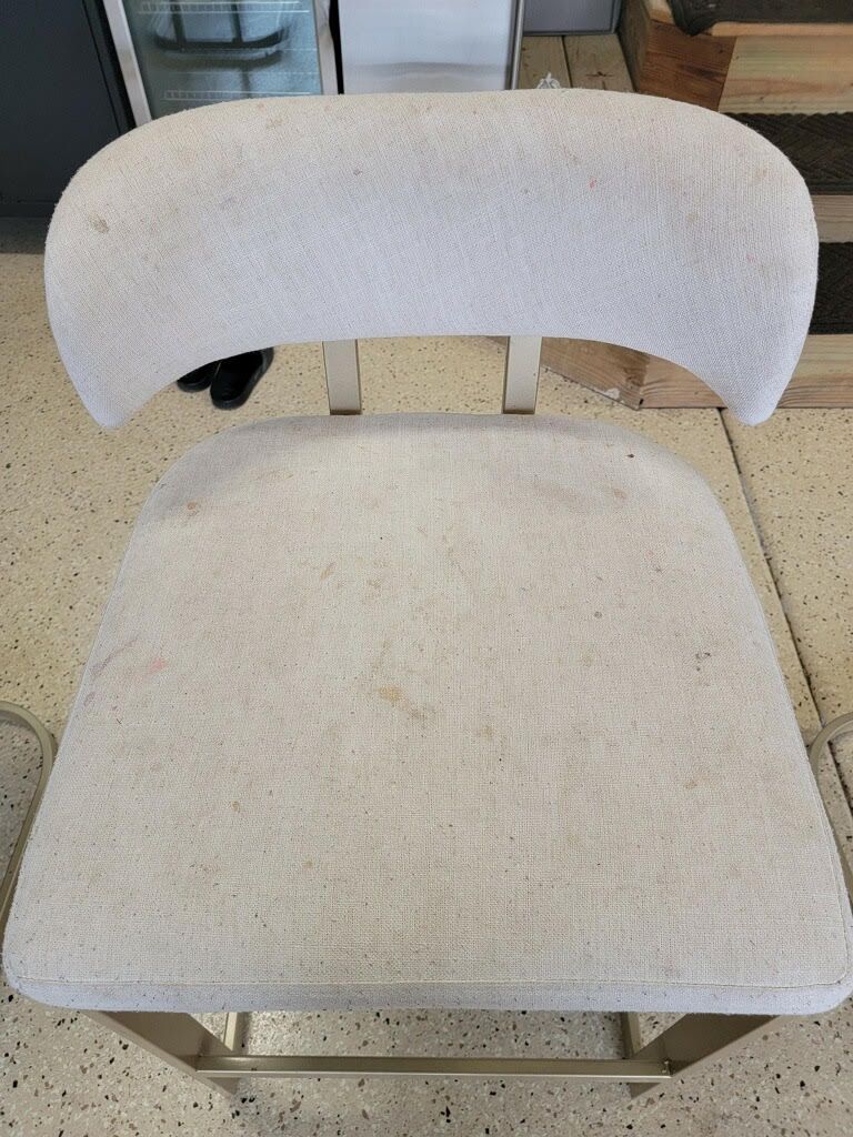 A white chair is sitting on a tiled floor.