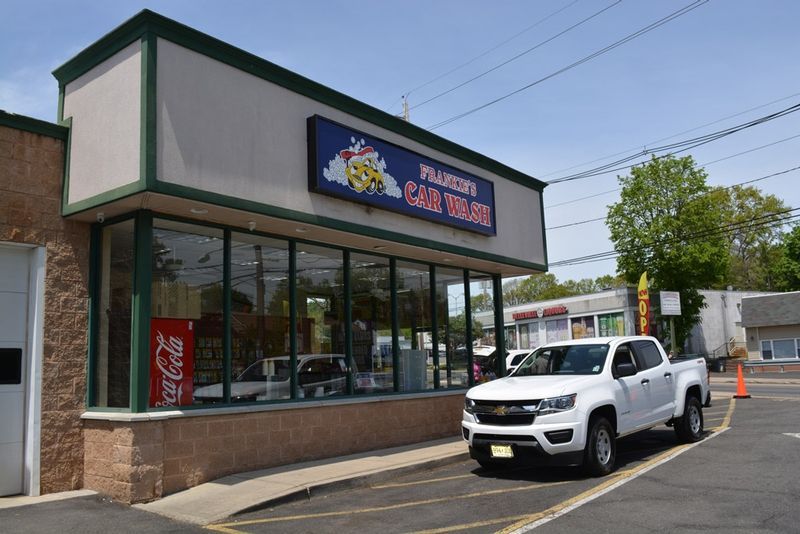 A white truck is parked in front of a restaurant.