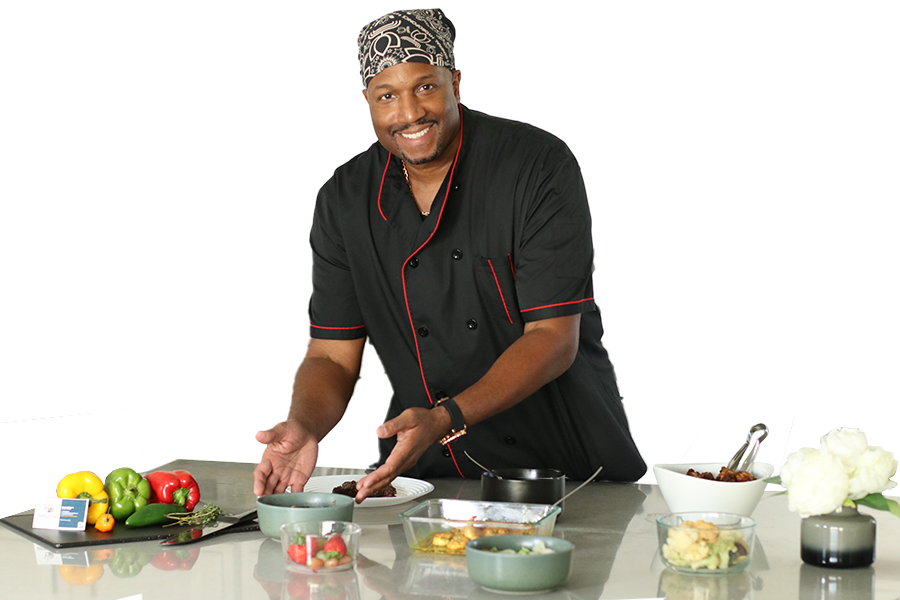 Kevin Walters the Diversity Chef in a chef 's uniform is preparing food on a counter.