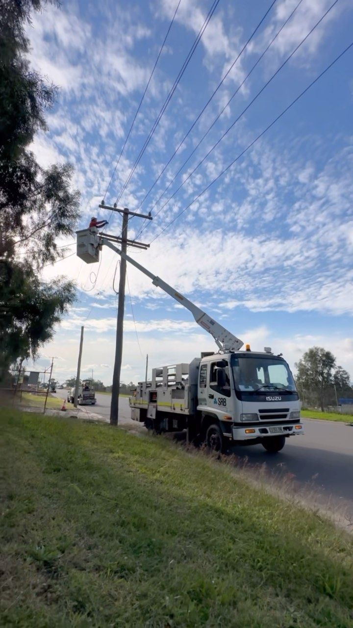 Utility Truck Working on Overhead Power Lines Beside a Road — SRB Electrical Contracting Pty Ltd In Davistown, NSW