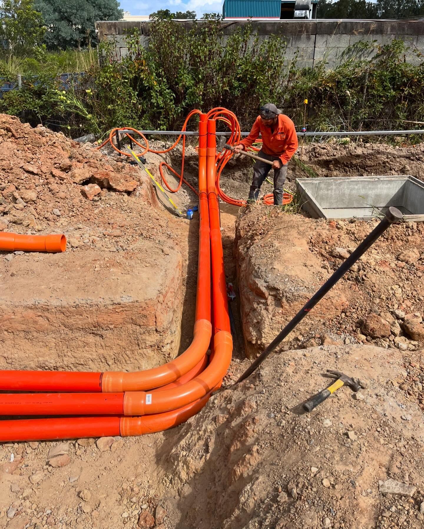 Worker Installing Orange Underground Cables — SRB Electrical Contracting Pty Ltd In Davistown, NSW
