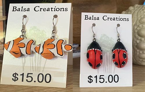 Handmade fish and ladybug earrings on display cards, each priced at $15.00