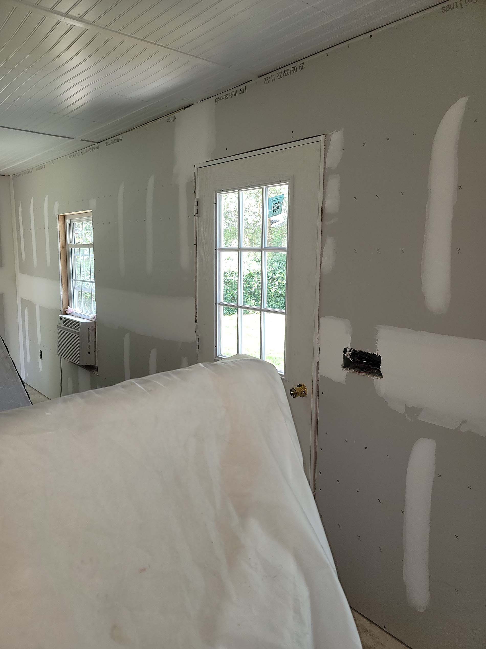 A room with drywall walls and a window.