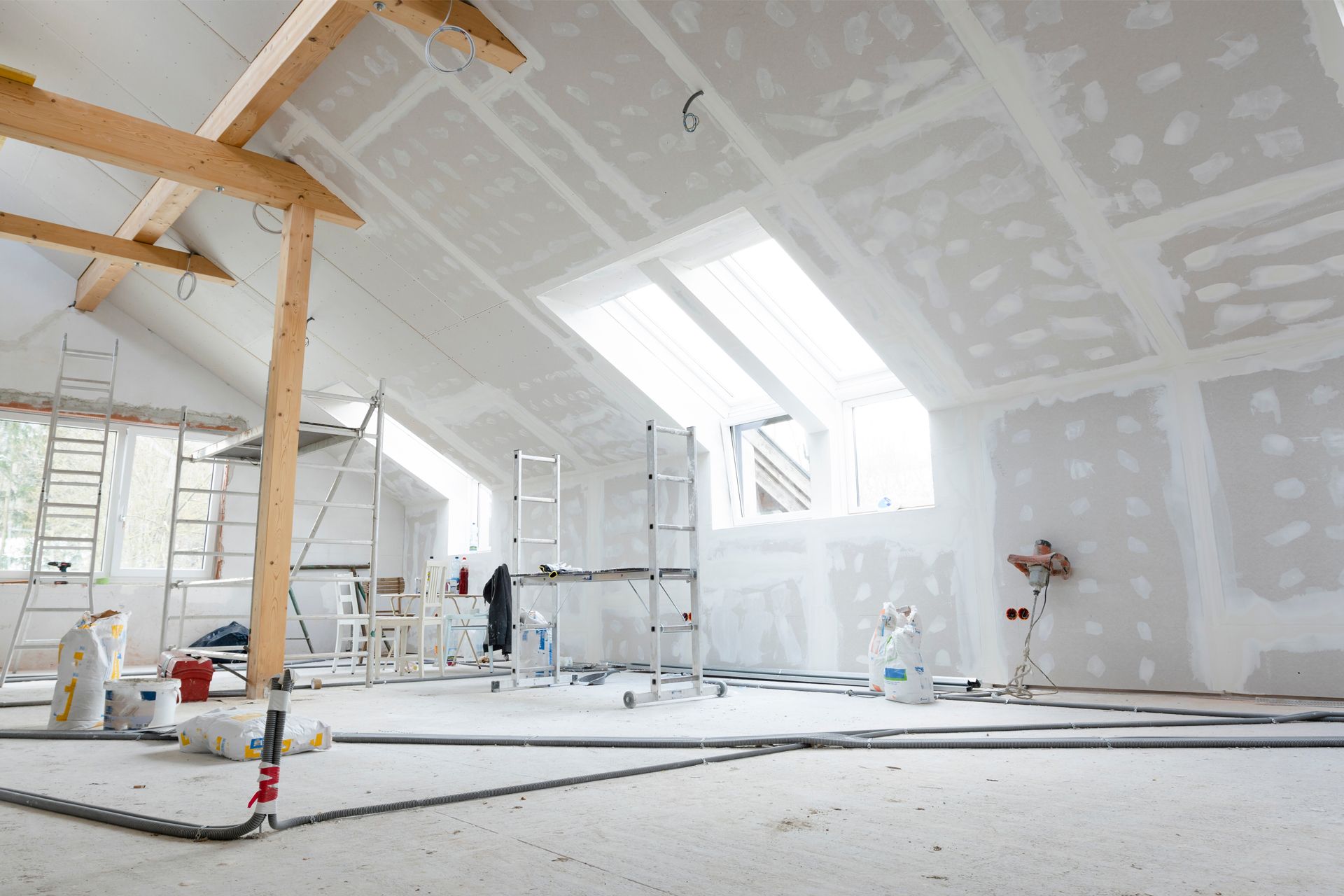 Two men are installing a ceiling in a room.