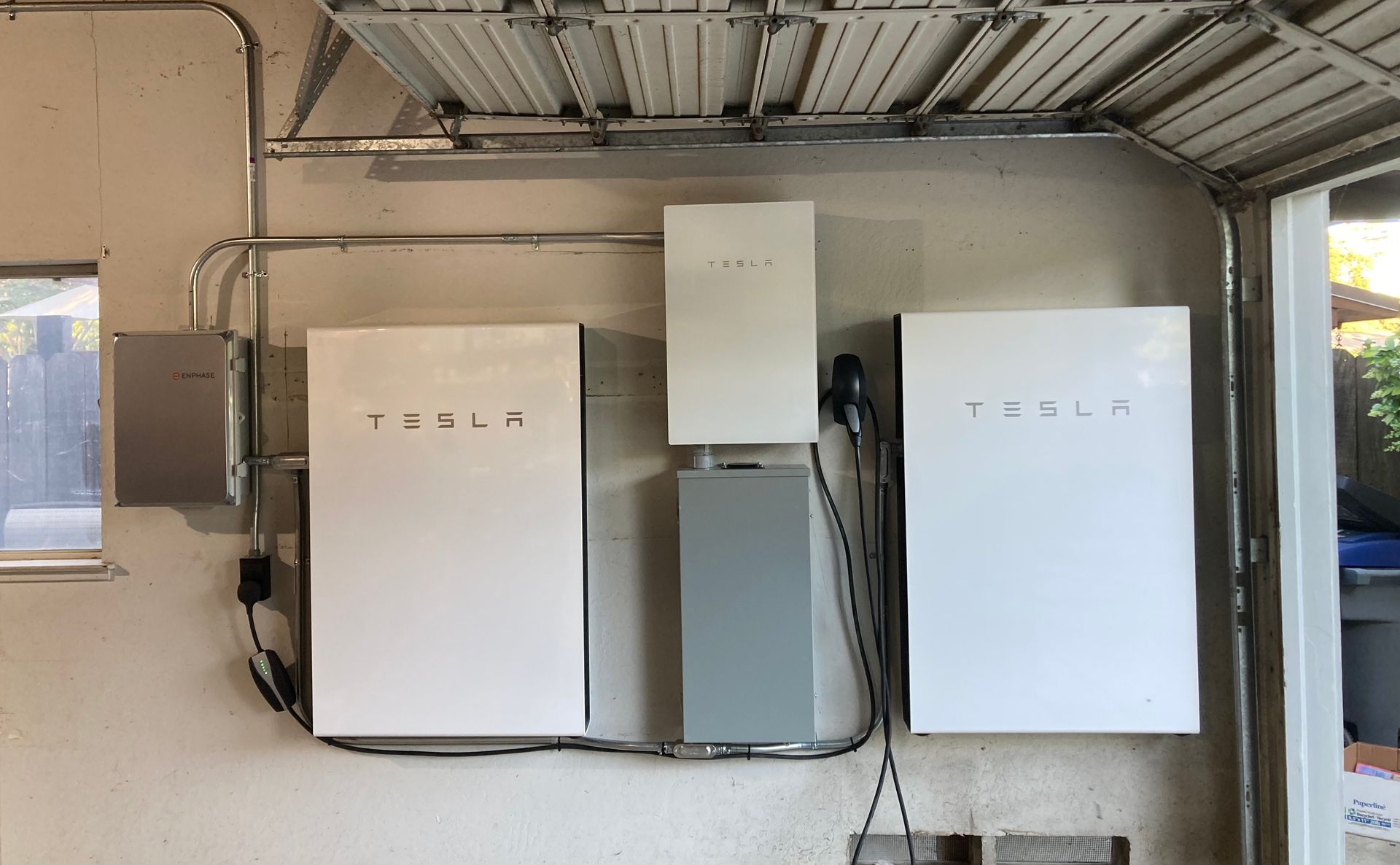 Two tesla solar panels are installed in a garage.
