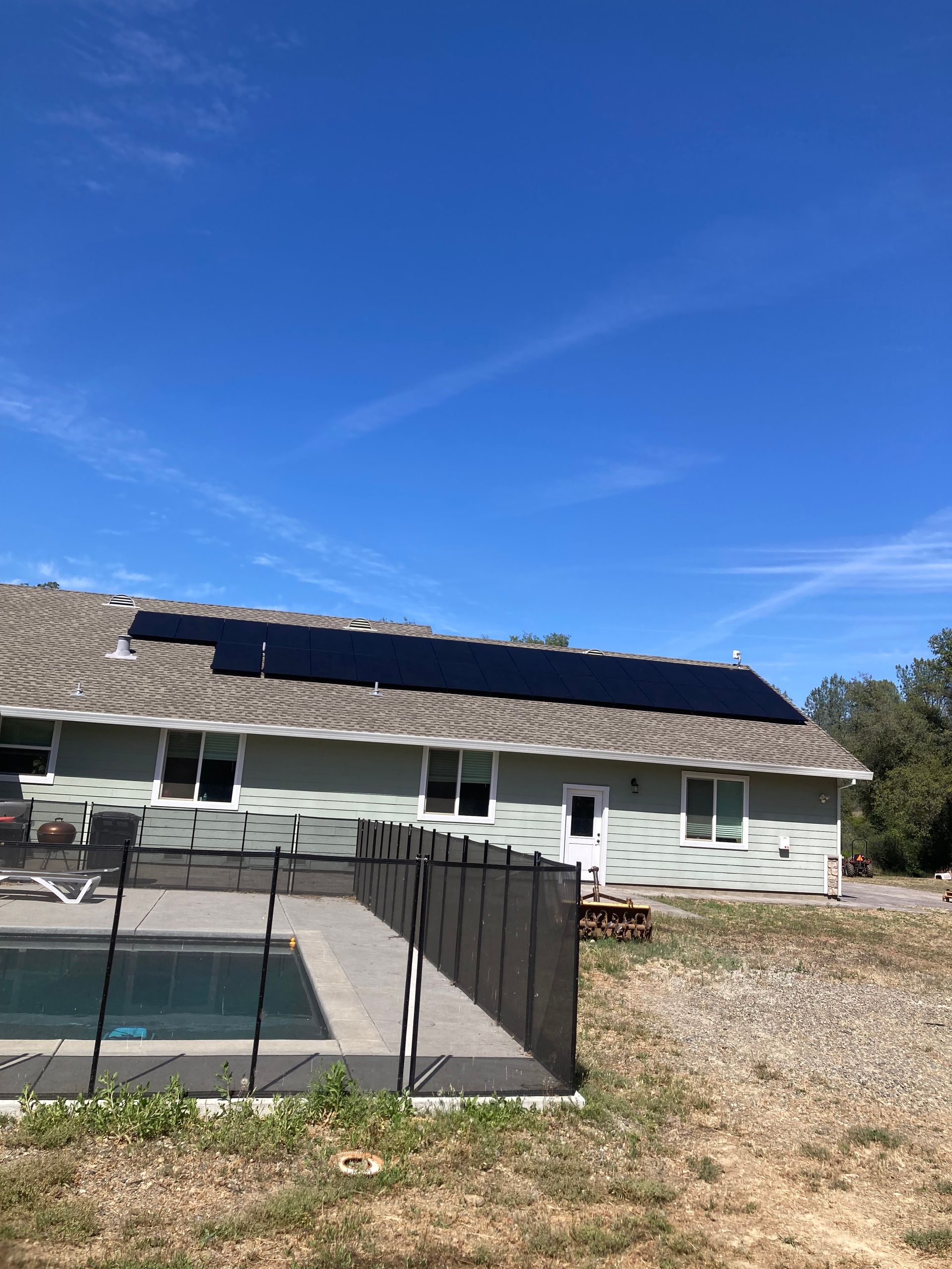 A house with a pool and solar panels on the roof.