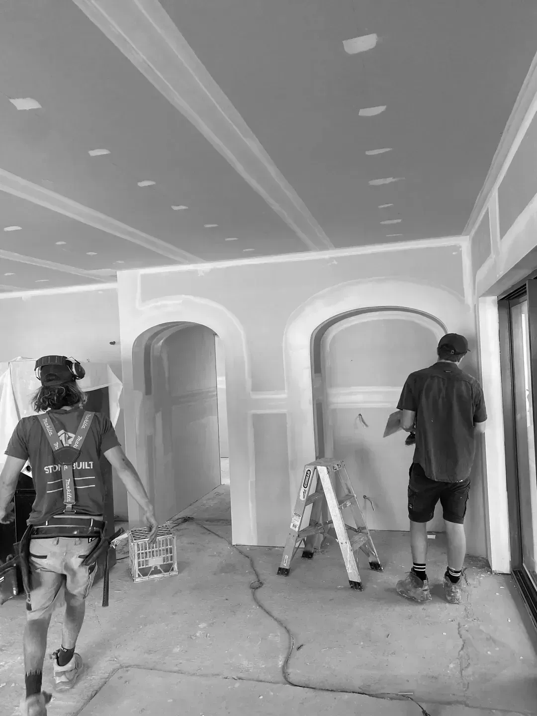 A Group Of Men Are Working On A Wall In A Room — MC Plastering In Fingal Bay, NSW