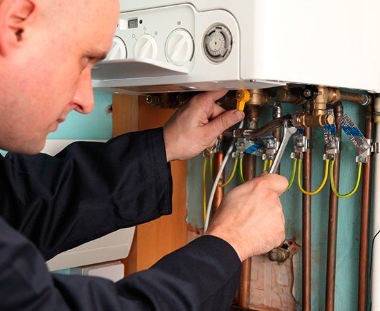 Plumber Installing Heater — Yorktown, VA — Dave's Plumbing Inc. Plumber Installing Heater — Yorktown, VA — Dave's Plumbing Inc.