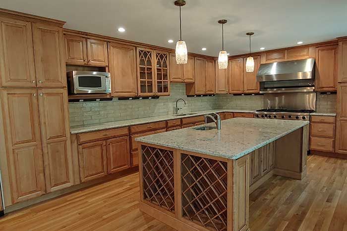 Spacious kitchen with wood cabinets, stainless appliances, and a large granite island with wine storage.