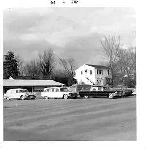 Black and white photo of parking lot with fleet of hearses for Mynatt Funeral Home, Inc.