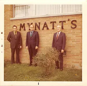 Three staff members standing in front of Mynatt Funeral Home exterior